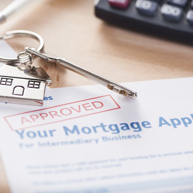 House-shaped key on an approved mortgage application